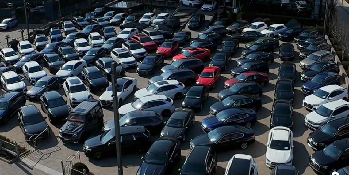 Aerial view of a full valet parking lot with luxury vehicles neatly arranged
